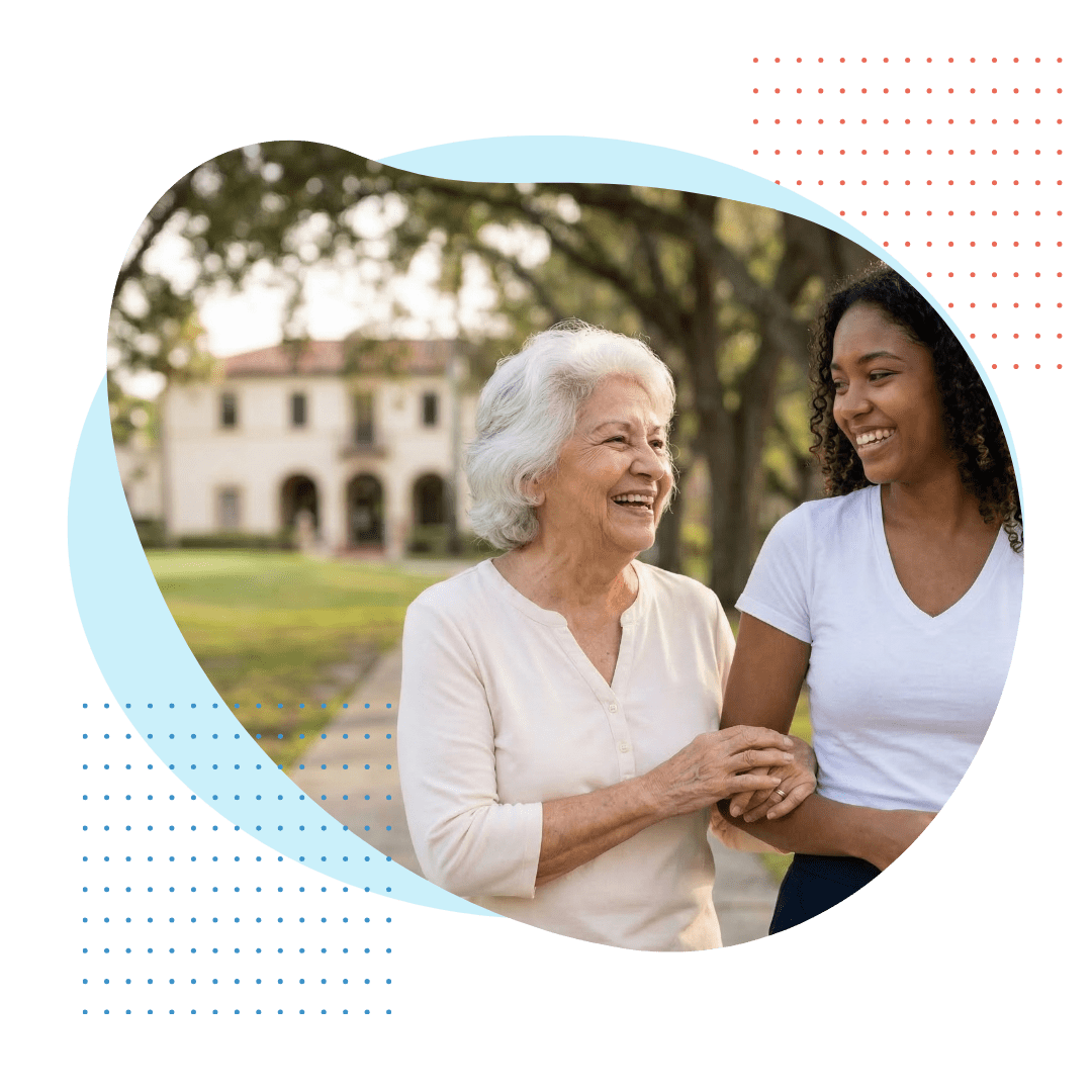 A close-up, natural light photograph of a smiling Hispanic elder and a younger female companion of African and Indigenous descent, walking and laughing together near a green, suggesting the Miami Springs Golf Course, representing personalized historic community companionship.